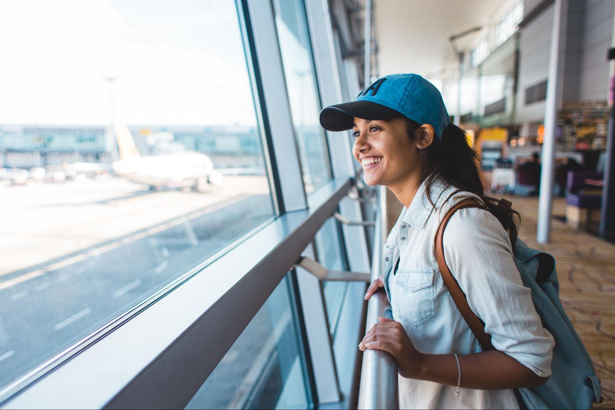 Woman looks out the window at the airport.